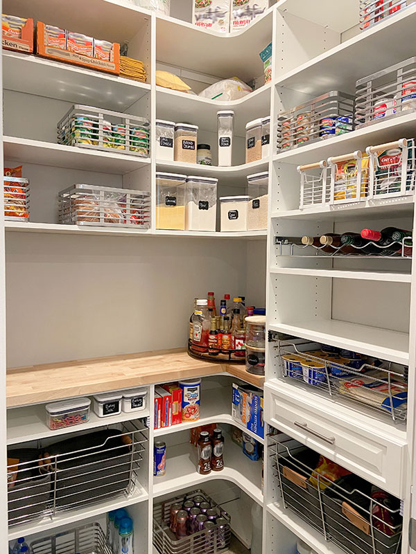 Small Custom Closets of GA pantry with white shelving, a wood countertop, wire baskets, drawers, and corner shelves.